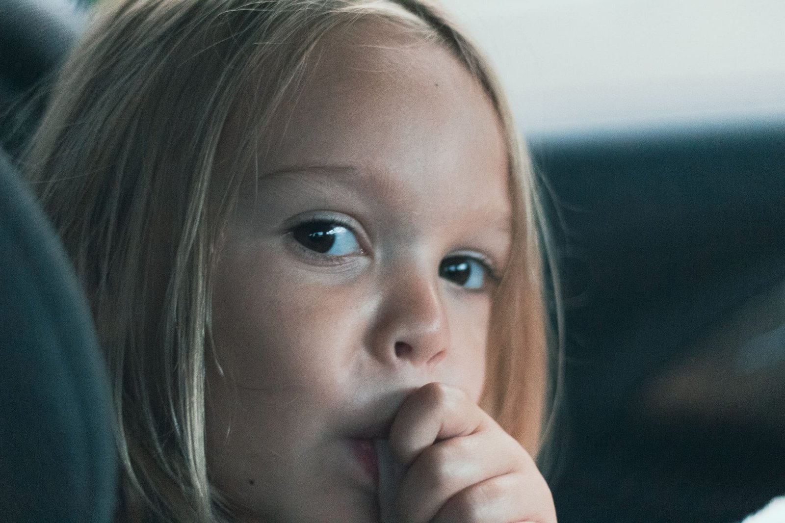 ritratto di una bambina che si succhia il pollice